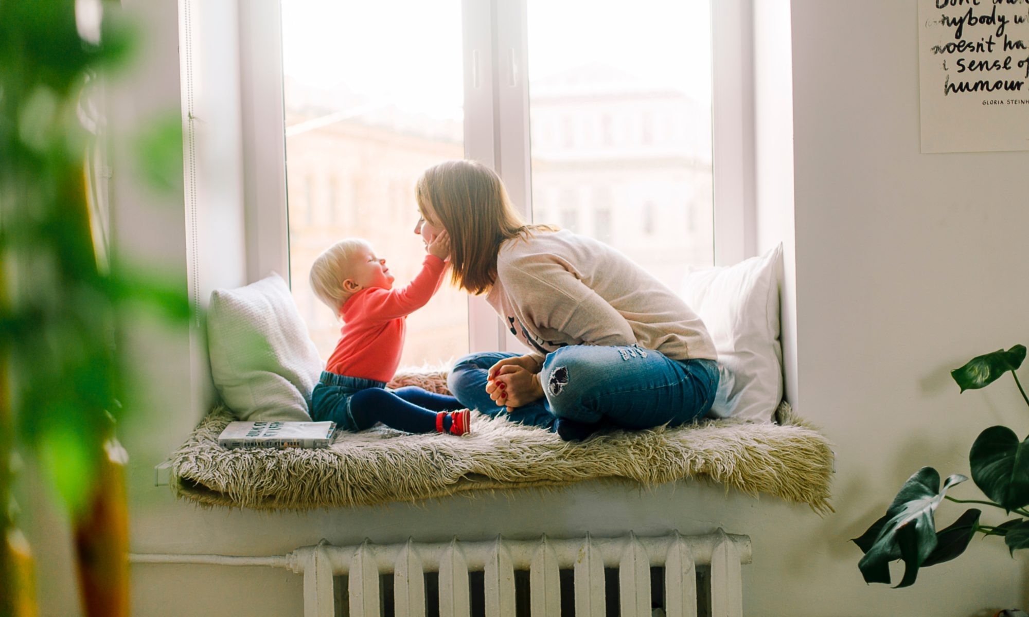 A young mom is playing with her baby at home.