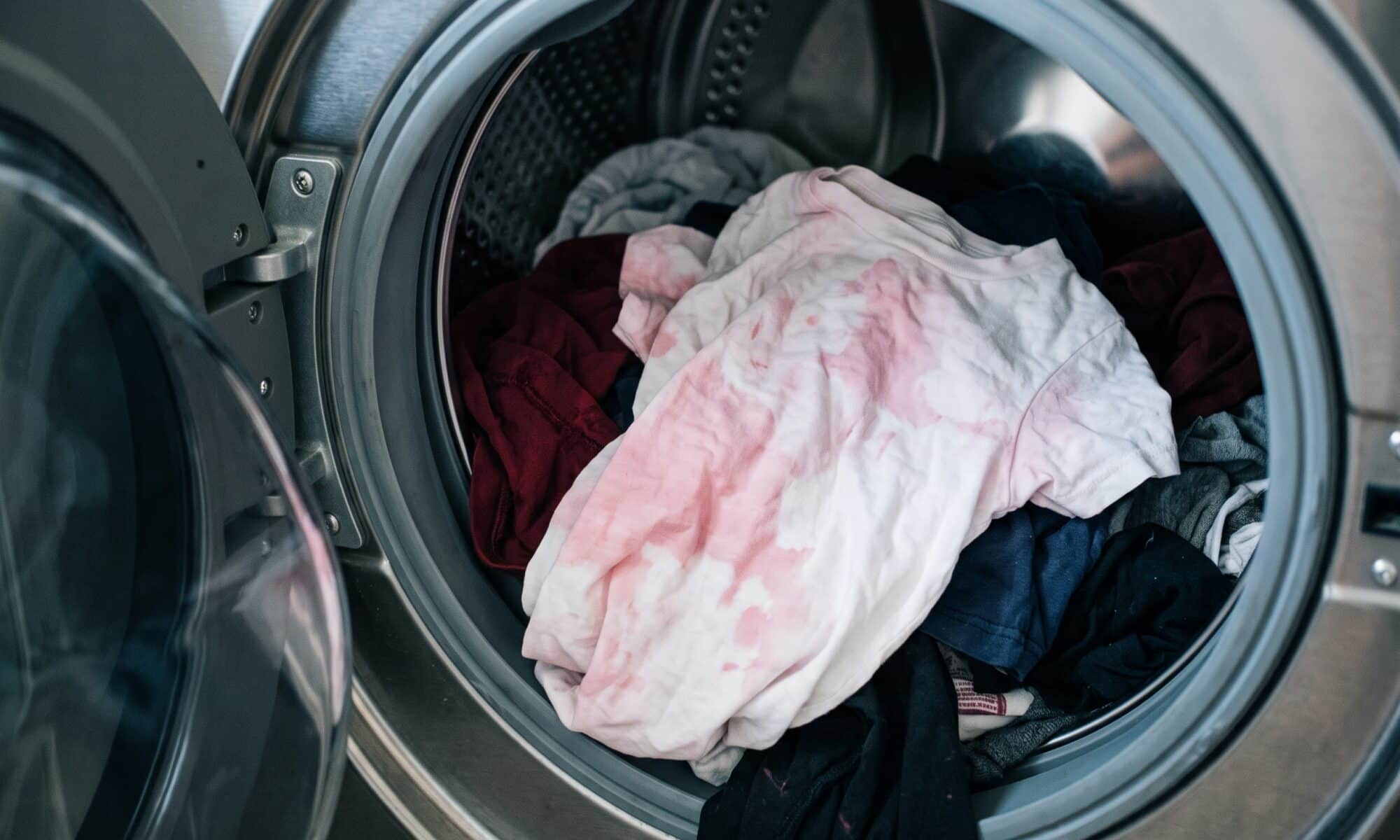 Pink-stained white tee in the washer drum